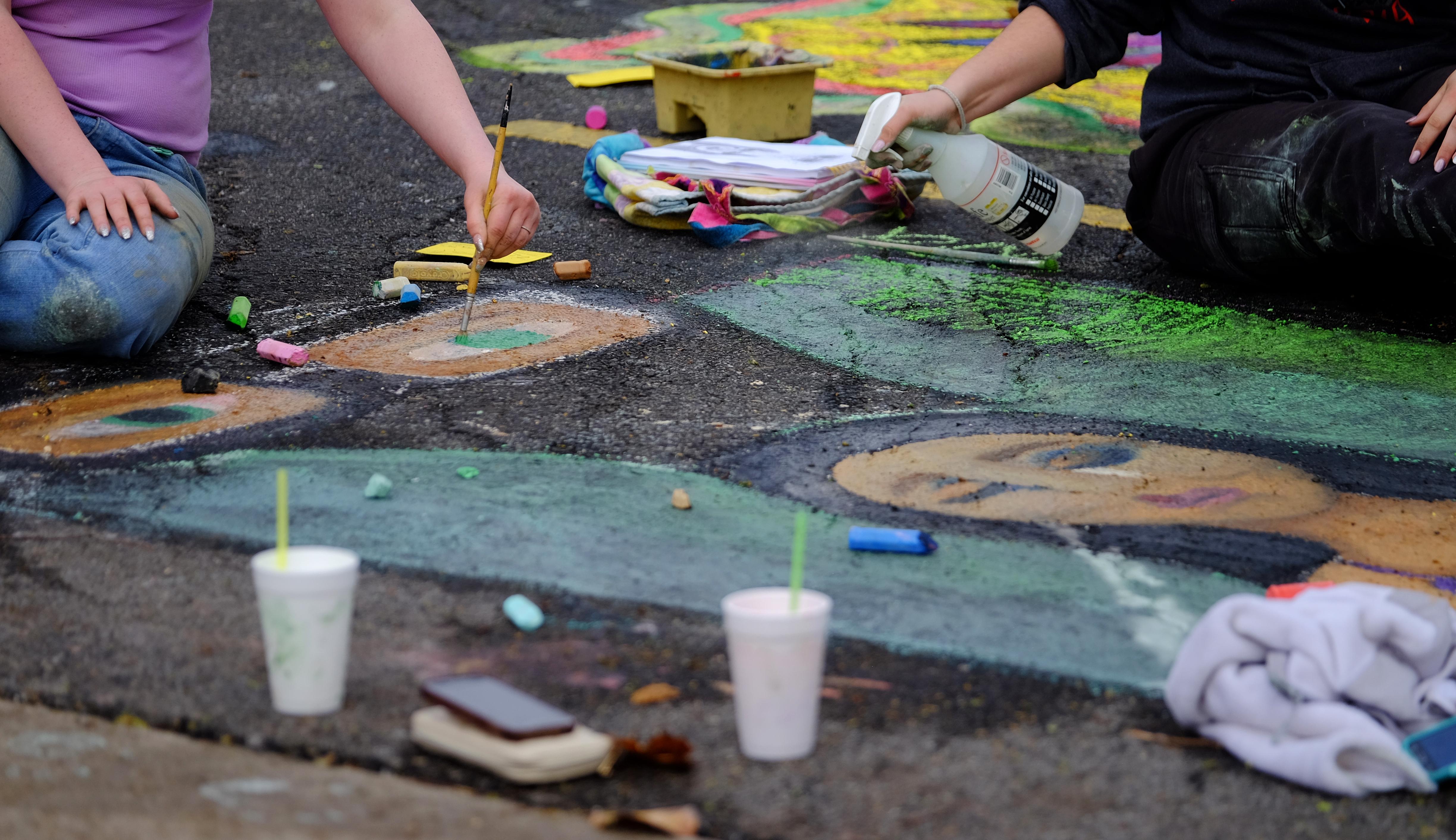 Students drawing and spraying their art with water