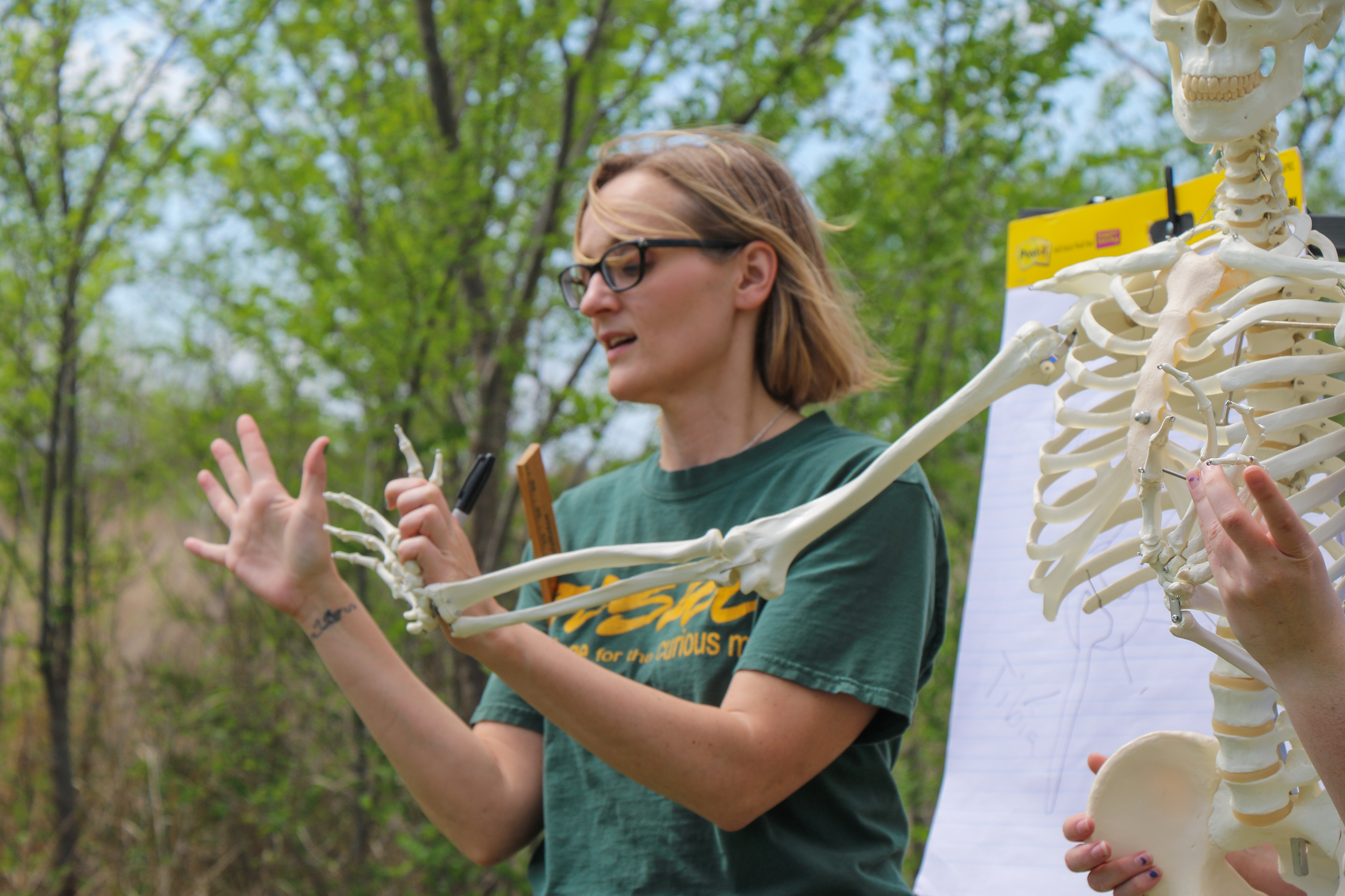 Dr. Jones holding up a skeleton hand beside her own.