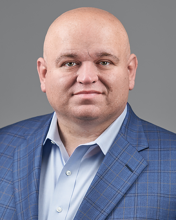 Regent JJ Francais facing the camera. Photo is a headshot of JJ with him in a light blue button up shirt with a darker blue plaid blazer. 