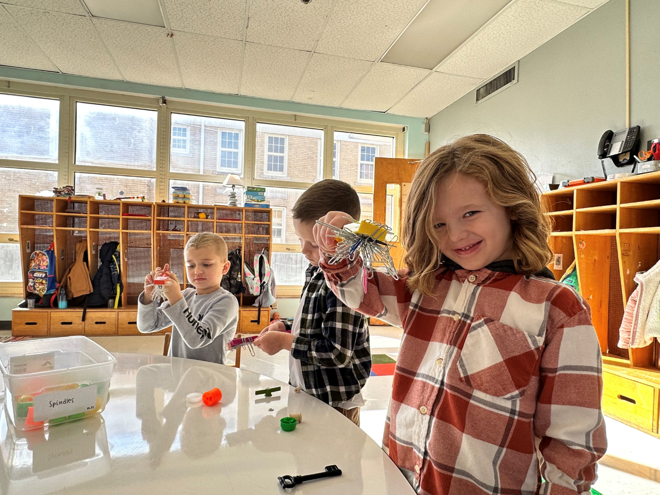 Children playing with items at a table.