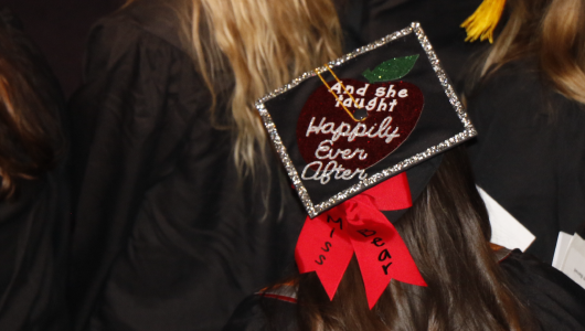 Image of graduate with hat that reads and she taught happily ever after