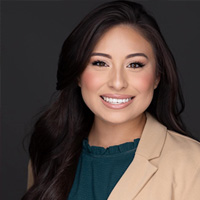 woman in tan blazer with teal shirt