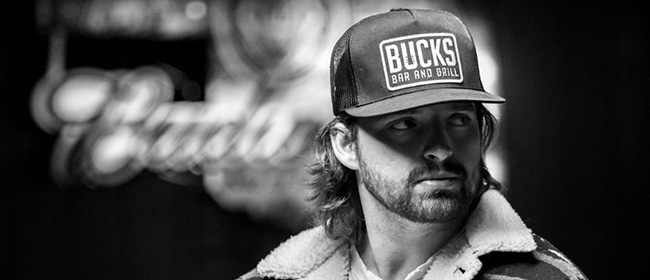 Black and white photo of a man wearing a trucker hat