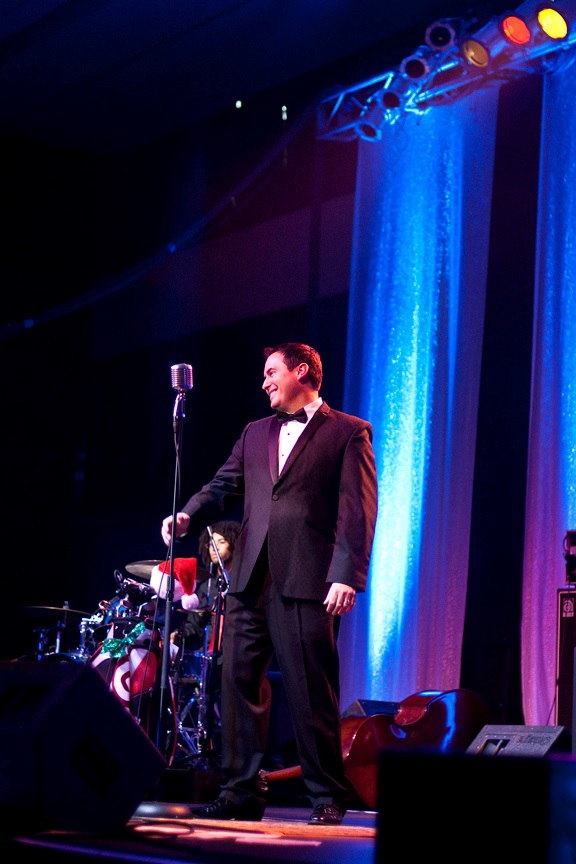 photo of Wade Tower holding microphone and smiling on stage