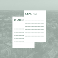 Two pieces of full-size sheet mockups for stationery overlaid on a light green image of campus from aerial view