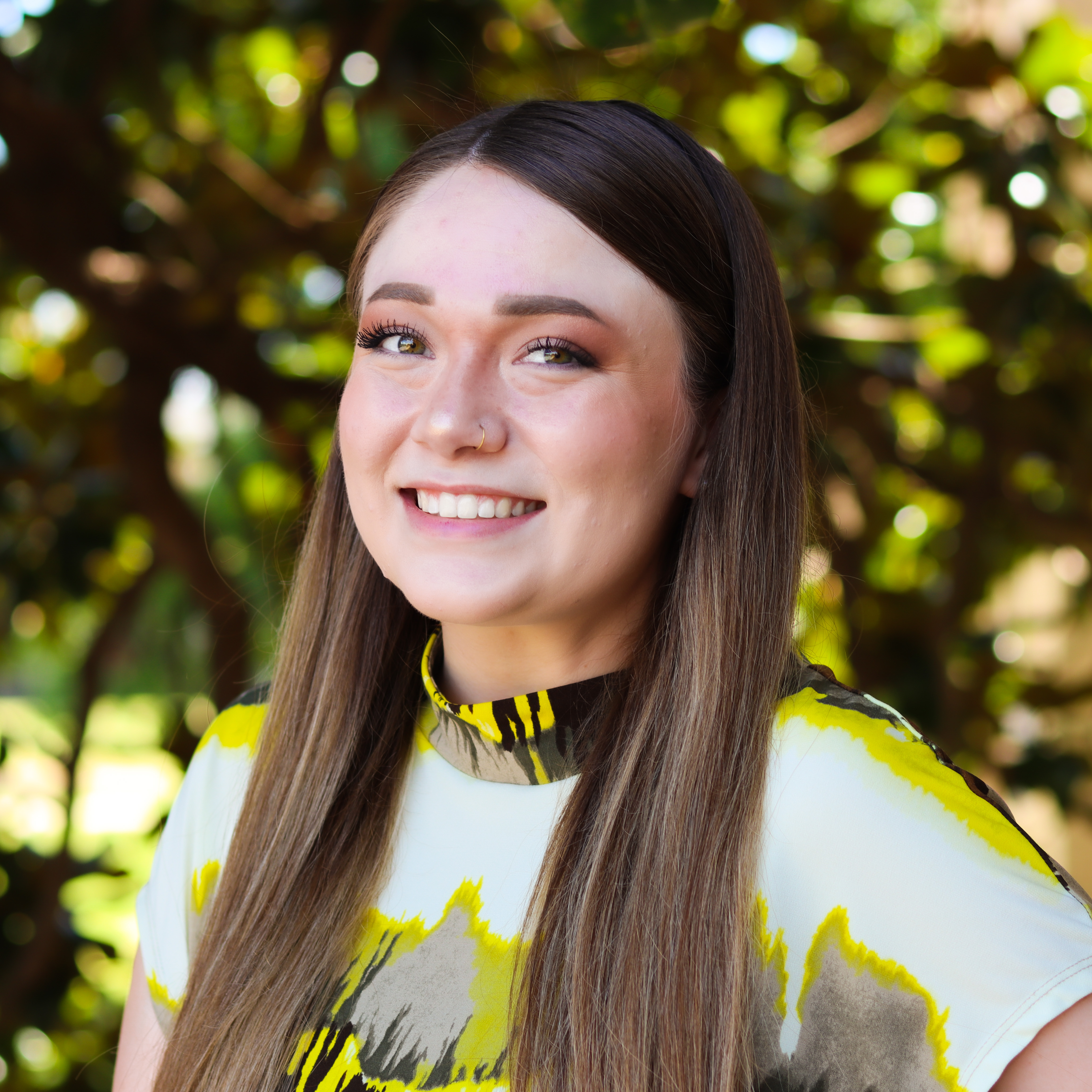 Woman smiling in yellow tie-dye shirt