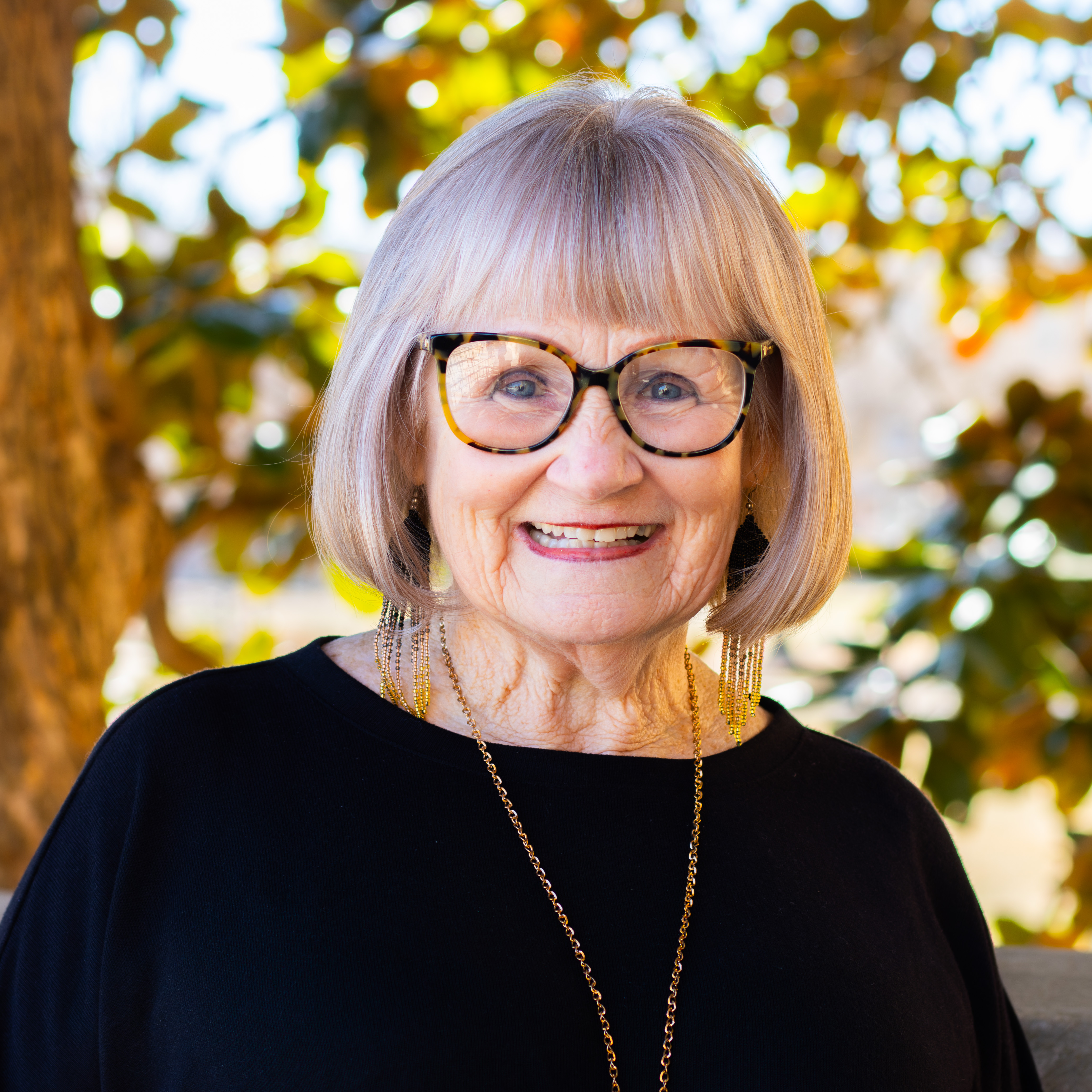 woman smiling in black shirt and glasses