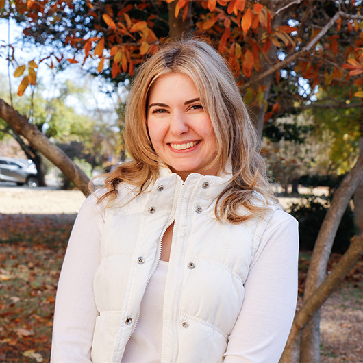 Malisa Rawlings, standing in front of fall foliage on campus