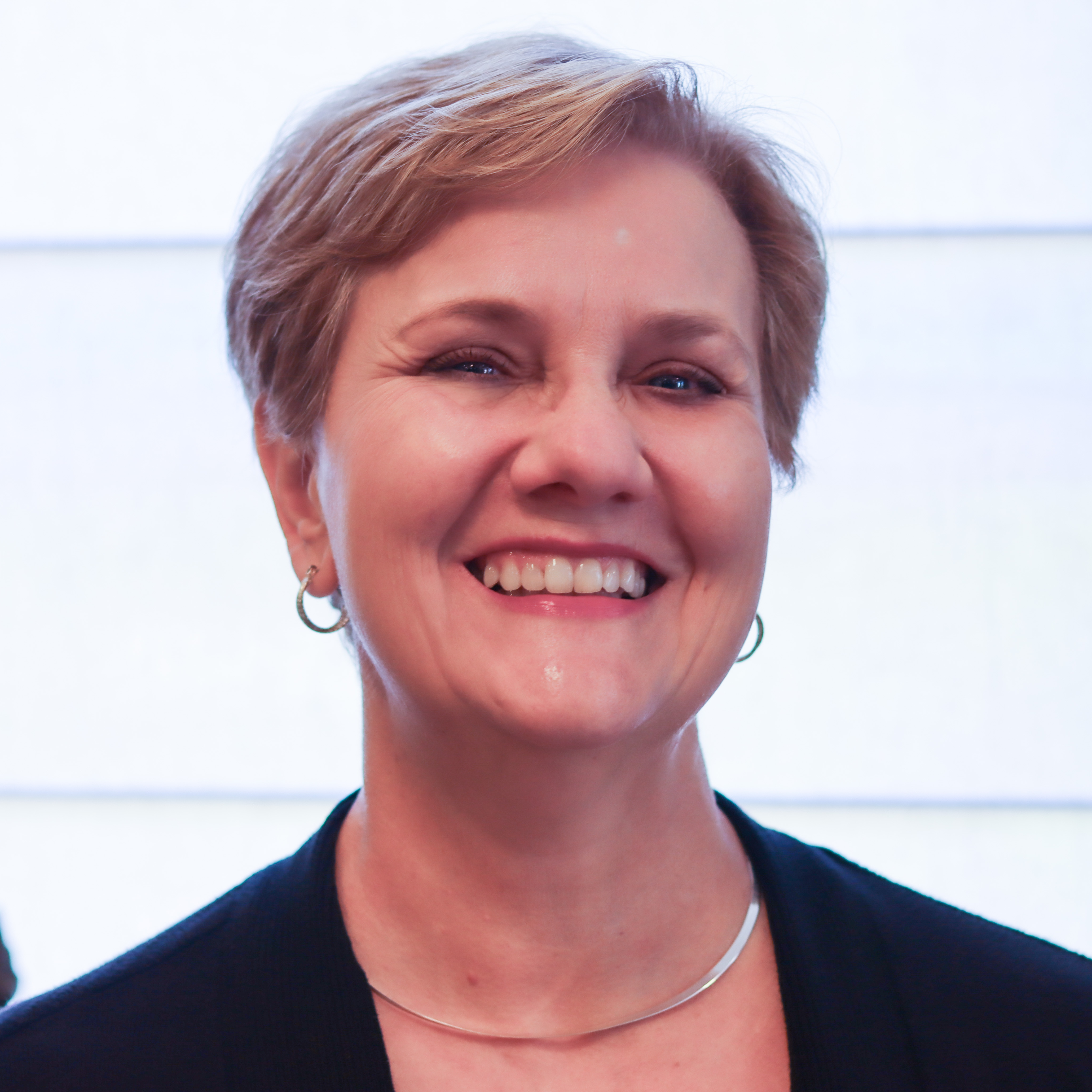 A photo of Sharon Greene smiling in a black blazer