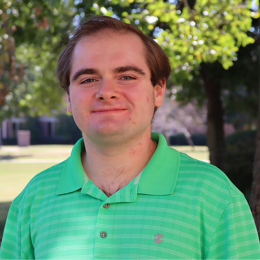 Smiling man in green striped polo shirt