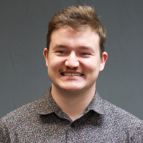 Smiling man with brown hair and floral print shirt