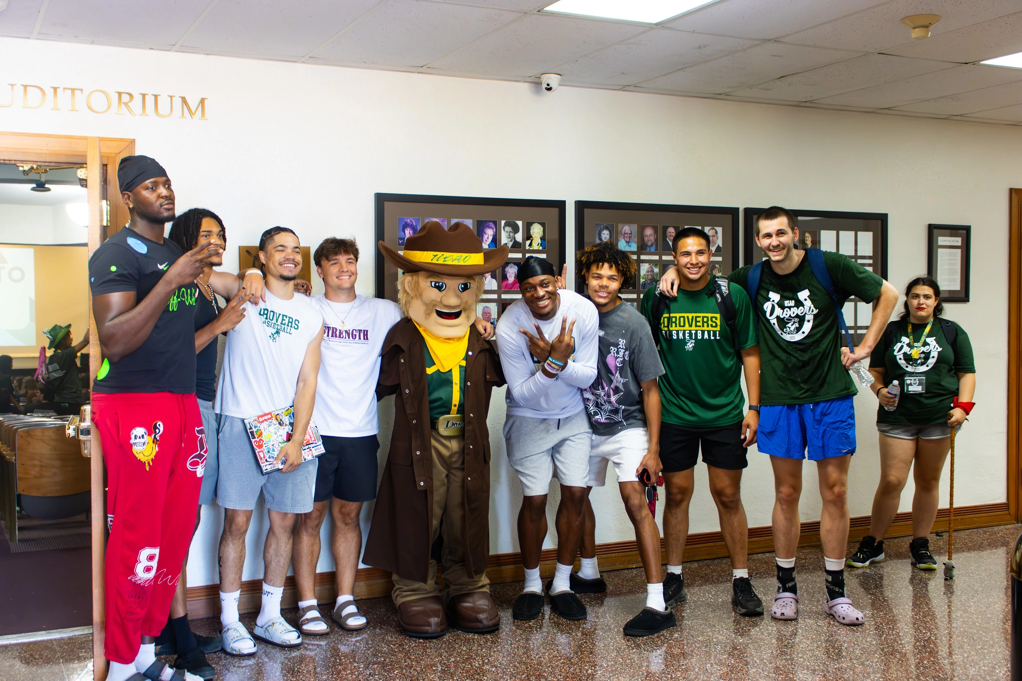Group of USAO students poses with the Drover mascot inside a campus building.