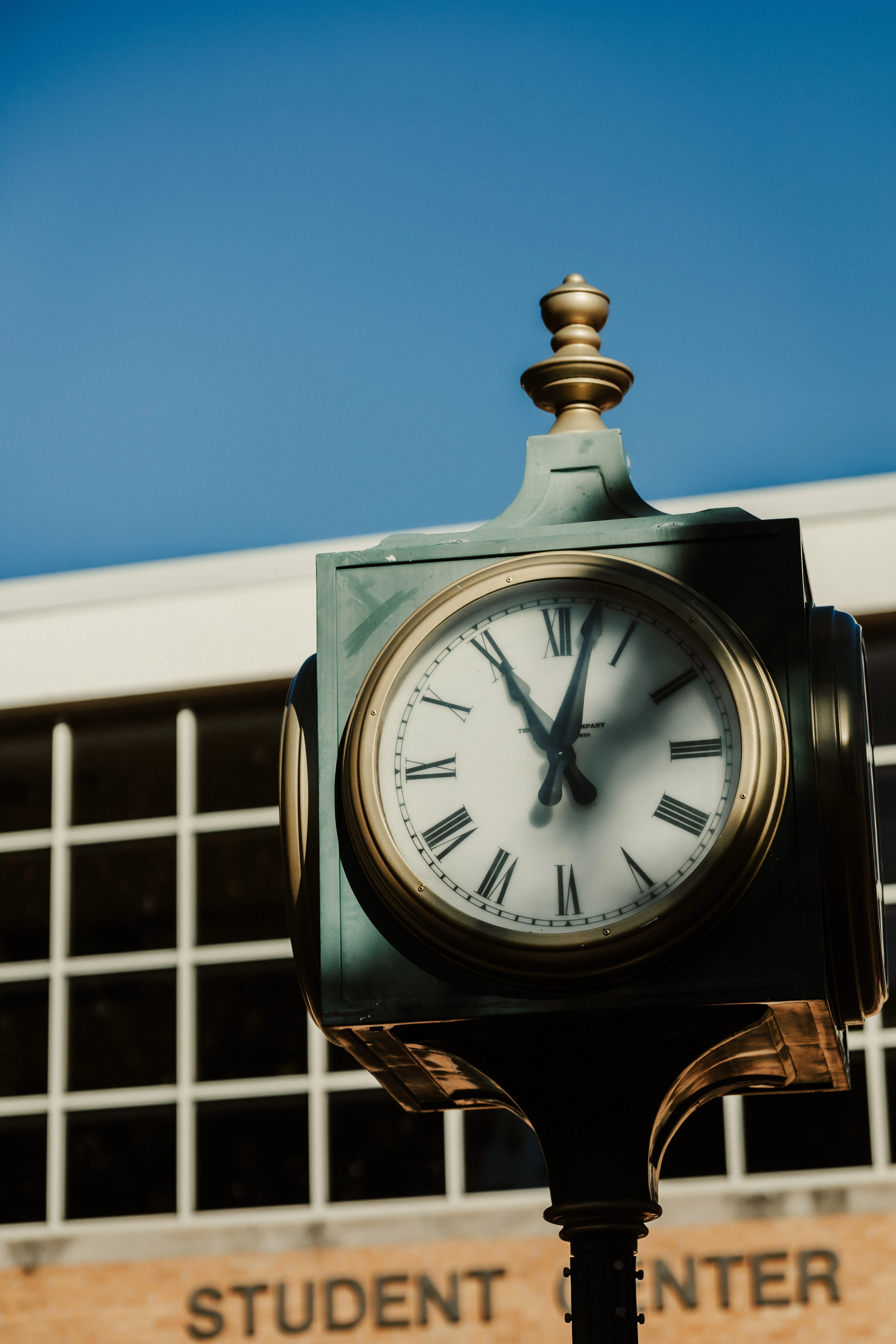   Outdoor campus clock with Roman numerals stands in front of the USAO Student Center.  Photo 3