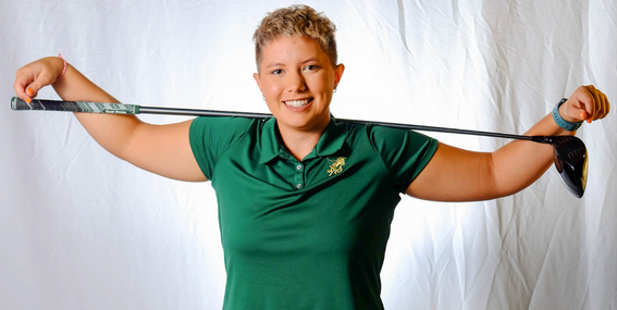 Allison Riddle smiling with a golf club behind their back.