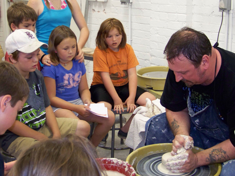 students watching a pottery lesson