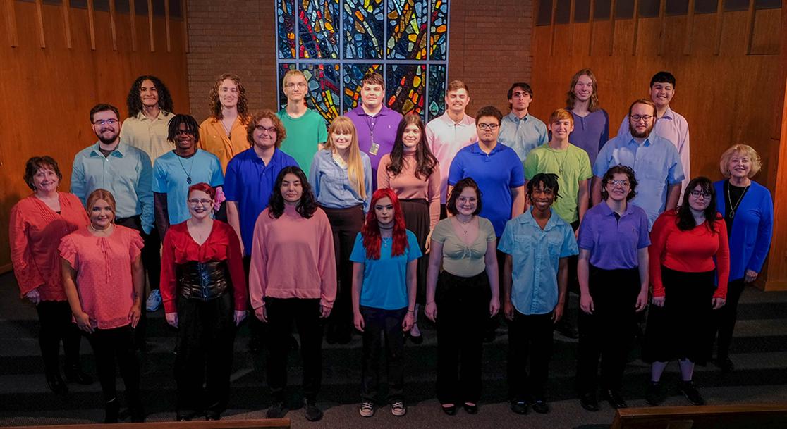 A photo of the USAO concert choir in three rows on the steps inside of the Alumni Chapel