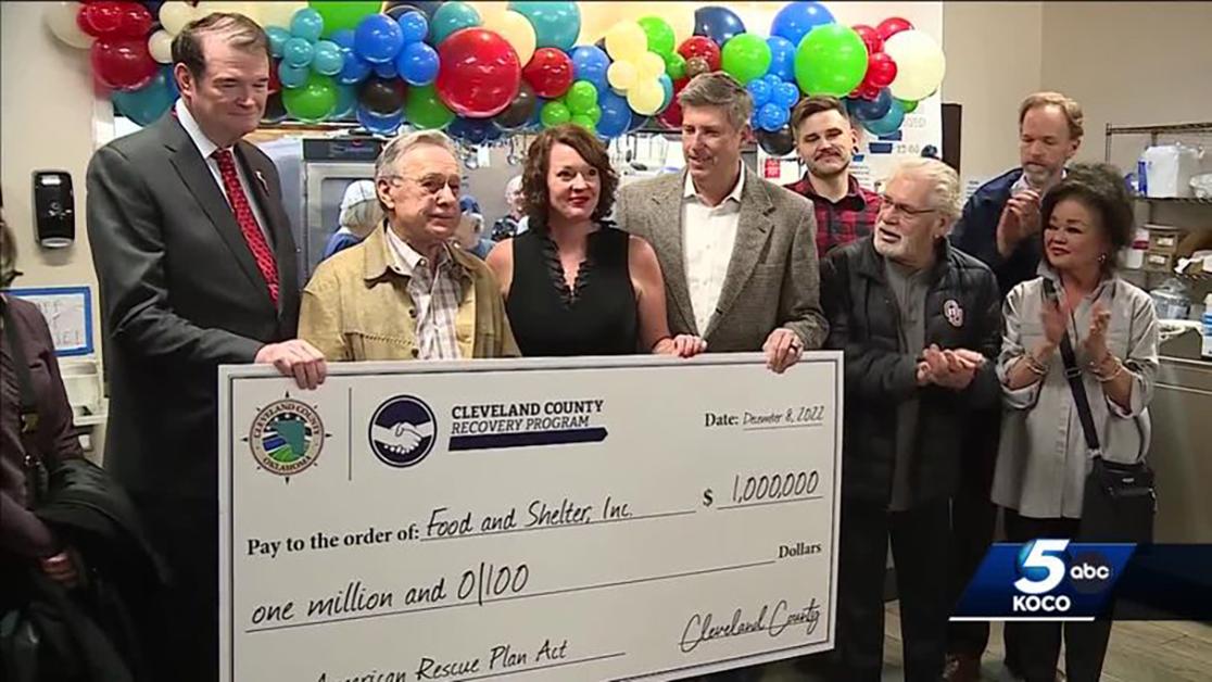 A photo of the Cleveland county commissioners presenting April Doshier's Food and Shelter organization with a $1 million check in American Rescue Plan funds