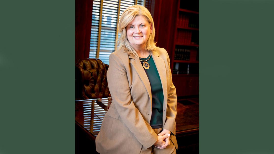 A headshot of President Kayla Hale with the grounds of the USAO campus in the background