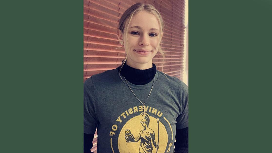 A headshot of Holly Dunivan in a USAO sweatshirt in front of some brown wood blinds