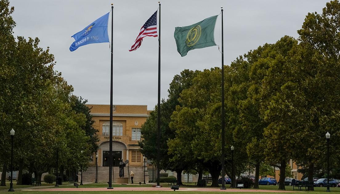 A photo of the Owens flag plaza, Te Ata statue and the front of Troutt Hall