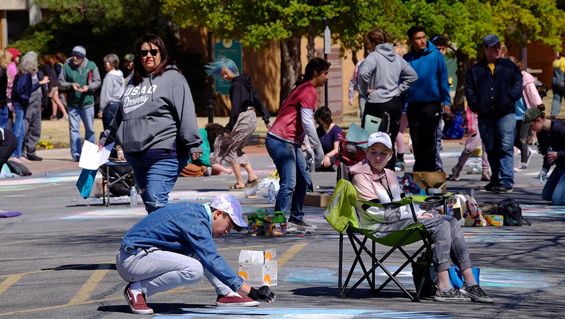 A photo of numerous students working on their chalk art pieces for the Montmartre festival