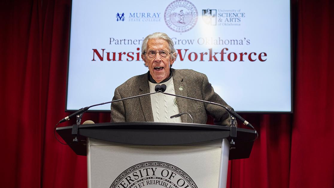 A photo of President Feaver speaking at a podium at the University of Oklahoma Health Sciences Center