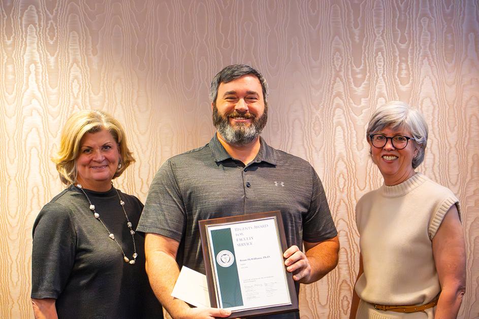 man smiles while recieving award