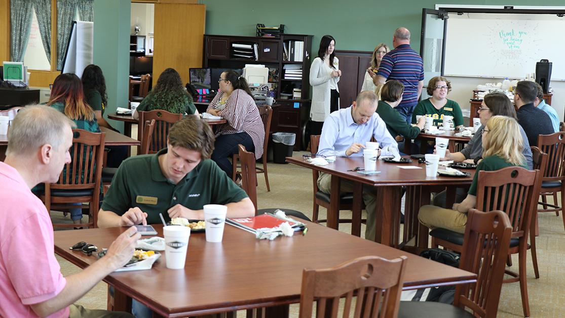 A photo of numerous students and faculty engaged in conversations at tables in Science & Arts' Student Success Center