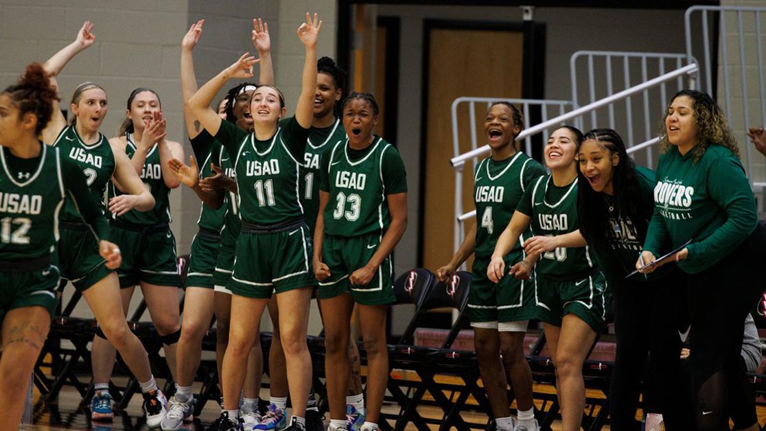 A photo of the Drover Women's basketball team cheering from the sidelines