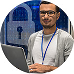 Man wearing glasses holding a computer.